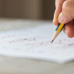 Student writing in an exam hall, representing the NEET PG 2026 exam