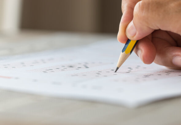 Student writing in an exam hall, representing the NEET PG 2026 exam